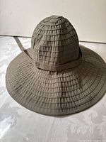 Front/side view of olive sun hat showing overall shape and brim