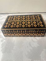 Closed box showing black lacquer and geometric light wood inlay