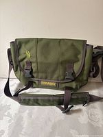 Front view of olive green Timbuk2 messenger bag showing buckles and strap
