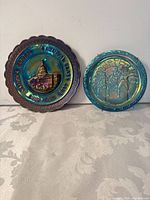 Two carnival glass plates side by side for size and color comparison