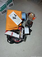 Group view of all items including booster cables pouch, shop towels, shammy, adapter box and flashlight