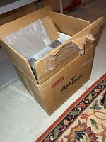 Sealed shipping carton with bubble-wrapped cabinet inside