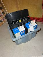 Four CD/DVD wallets standing in plastic bin