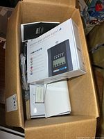 Open carton showing two boxed Uniden U65P boosters with accessories