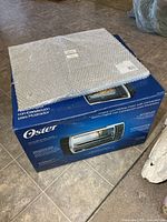 Boxed Oster digital countertop convection oven with bubble-wrapped mat on top