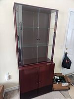 Front view of assembled two-piece cabinet showing glass doors and wood base