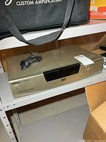 Front and top view of Raite AV Phile 703 DVD player on shelf