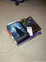 Stack of DVD movies resting on Sony player box