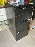 Front view of black metal 3-drawer filing cabinet
