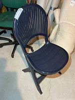 Front view of dark blue resin folding deck chair showing slatted back and seat