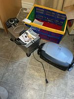 Deep fryer and grill with manual visible on floor