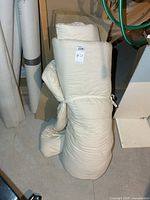 Rolled off-white futon mattress pad standing upright