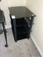 front view of black glass 4-tier shelf unit
