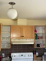 Overview of two open kitchen cupboards showing clear glasses, mugs and water bottles