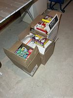 Three cardboard boxes filled with various packaged light bulbs