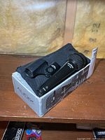 Microphone in box with clip and pouch visible