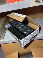 Pedal inside original box showing diamond-plate treadle