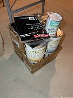 Box containing gallon paint cans, quart can, drop sheets, accessories