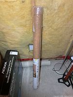 Shade in original plastic wrap leaning against wall