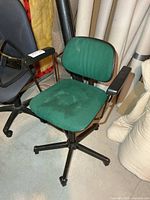 Front view of green upholstered office chair with arms and five-spoke base