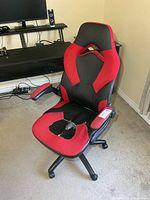 Full view of chair highlighting red and black upholstery and torn seat