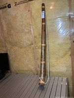 Full view of wooden horn leaning against wall