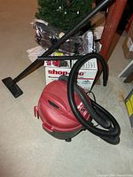 Vacuum with hose, floor nozzle, box, extra hose in package visible