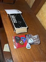 Seiko chromatic auto tuner box next to bag of assorted guitar picks