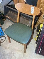 Front view of wooden chair with green vinyl seat