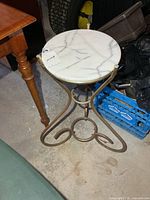 Full view of round marble-top metal stand