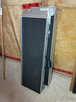 Two folded aluminum wheelchair ramps standing upright