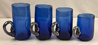 Four cobalt blue art glass mugs in size order