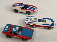 Overview of three Aurora slot cars