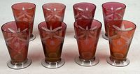 Front view showing all eight cranberry flashed wheel-cut tumblers