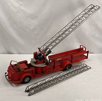 Complete fire truck with one ladder installed and one detached displayed beside