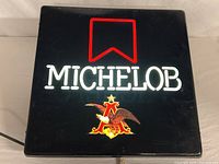 Front view showing illuminated MICHELOB text, red ribbon, eagle-A logo