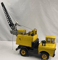 Full view of yellow pressed steel crane with boom extended