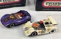 Purple Dune Buggy and white Chaparral 2G slot cars side by side