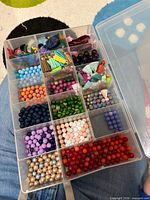 Clear organizer showing multicoloured round beads and tassels
