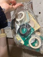 Bag of tape rolls in original square cardboard packages, various colours visible