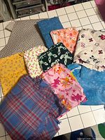 Overview of nine quilting cotton fabric pieces in assorted colors and prints