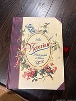 Front cover of Victorian photograph album showing title and floral design
