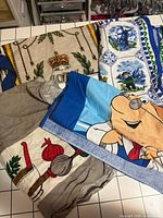 Overview of four tea towels showing variety of graphics