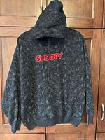 Full front view of Bewakoof Snoopy hoodie hanging