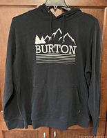 Full view of black Burton hoodie on hanger