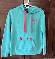 Front view of hoodie on hanger showing colour, drawstrings, pocket