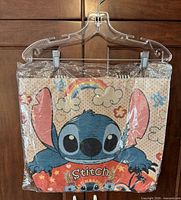Full tote bag in plastic showing Stitch graphic and straps