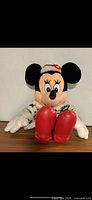 Front view of Minnie Mouse plush showing coat, gloves, shoes
