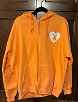 Full front view of orange Playboy zip-up hoodie on hanger
