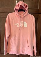 Front view of pink The North Face hoodie with logo